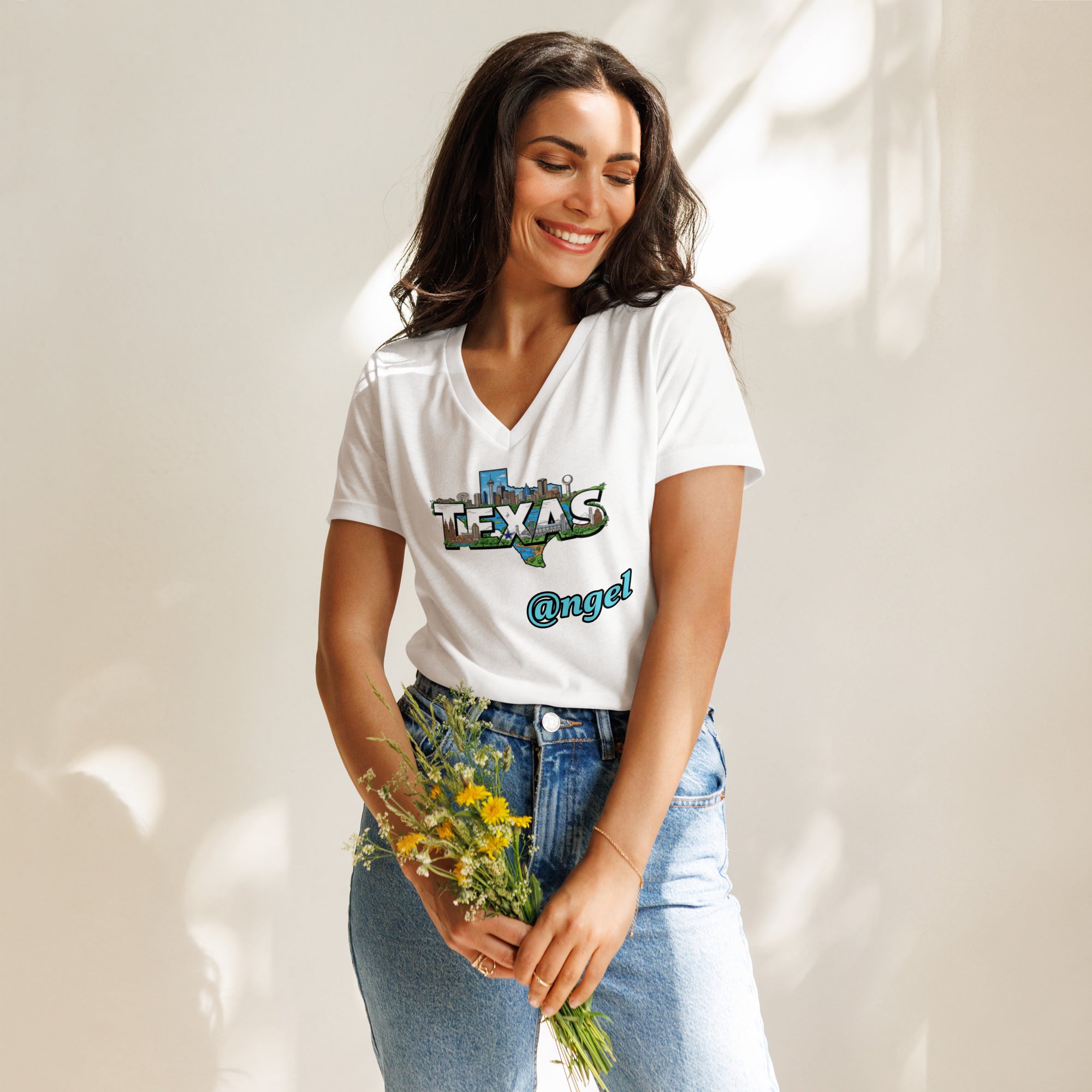 Woman wearing a white t-shirt with 'Texas Angel' text, holding flowers against a neutral background