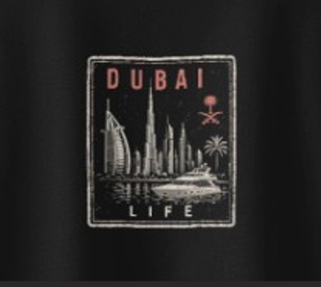 Extreme close-up of the Dubai Das Hot! Passport™ Dubai Life badge on the back of a black Das Hot! oversized streetwear T-shirt featuring the Dubai skyline, luxury yacht, Burj Al Arab, Burj Khalifa, and UAE-inspired design.