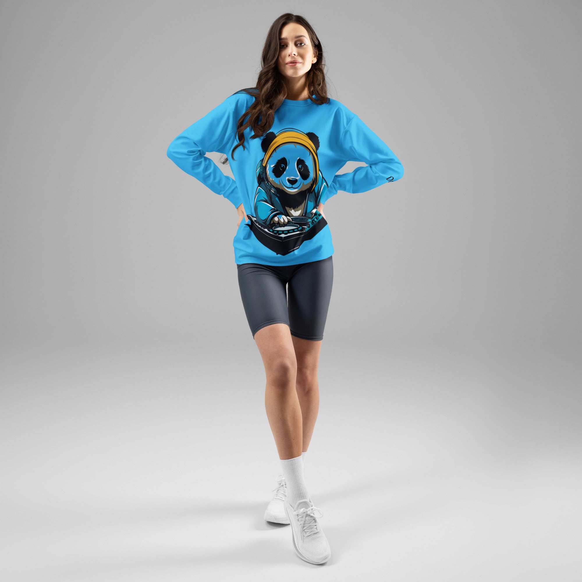Full-body studio shot of a model styling the unisex cyan blue DJ Panda graphic streetwear sweatshirt by Das Hot with dark shorts and white sneakers.